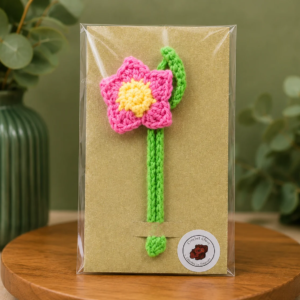 Handmade crochet pink flower bookmark with braided stem and elegant design