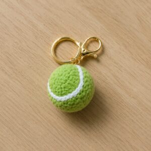 Handmade crochet tennis ball keychain with soft sports charm and metal clip