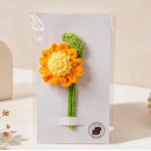 Handmade crochet marigold bookmark with colorful floral design and green leaf